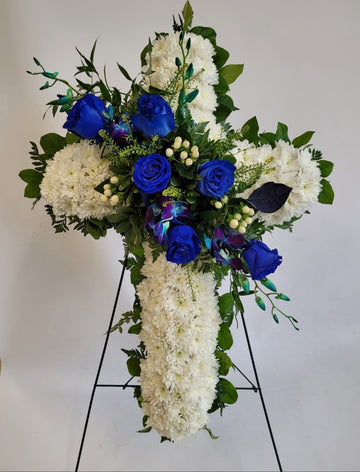 Croix blanche avec gerbe de roses bleues.