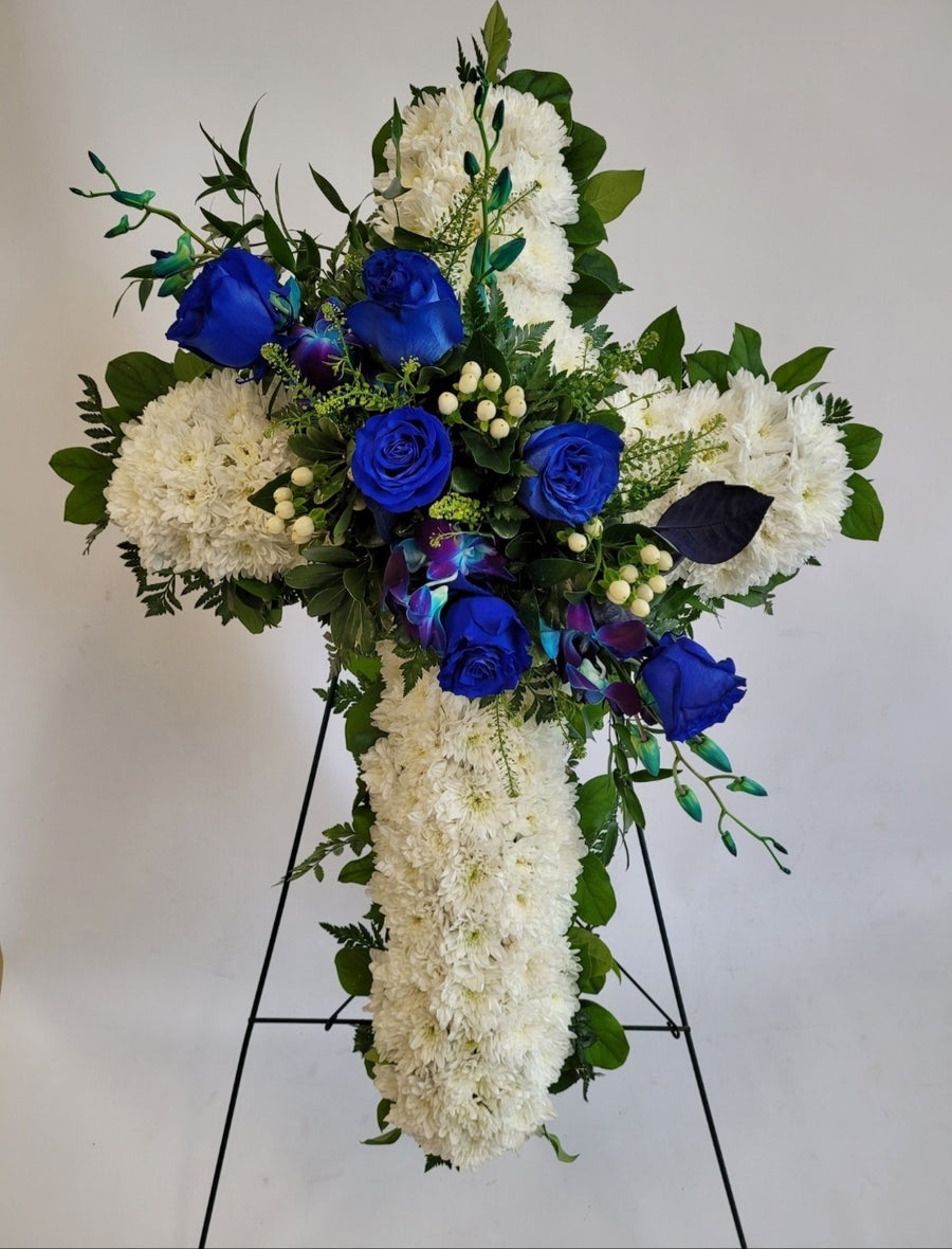 Croix blanche avec gerbe de roses bleues.