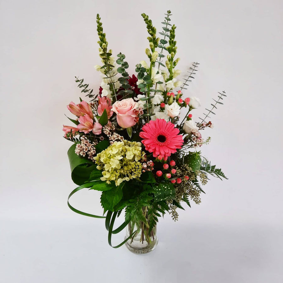 Arrangement dans un vase teintes de rose et blanc