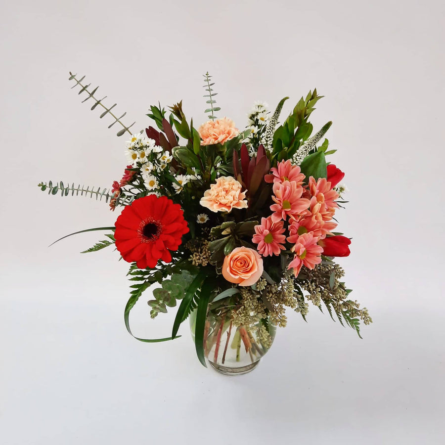 Arrangement dans un vase teintes de rouge/blanc/pêche