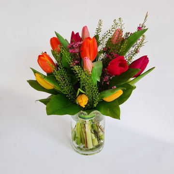 C) Arrangement de tulipes assorties de couleurs en vase